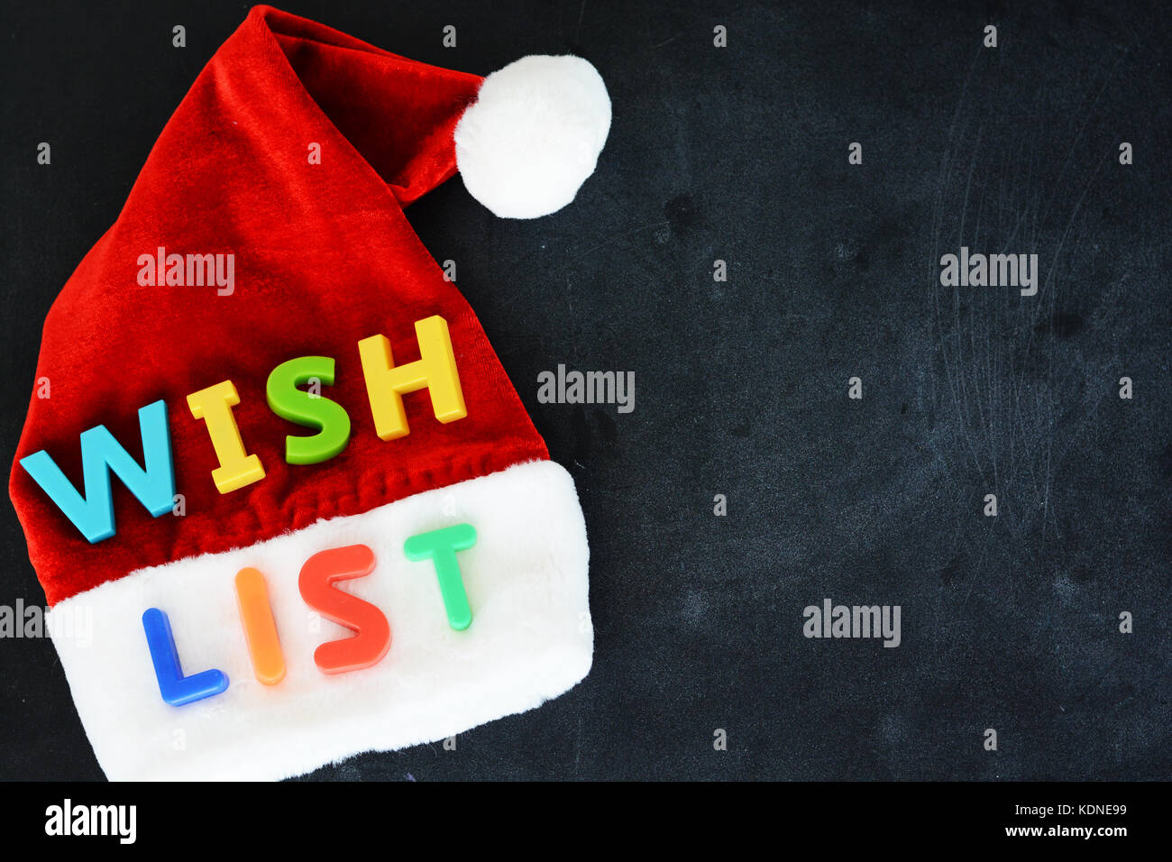 Santa Claus wish list concept with colorful text on Santa’s red hat Stock Photo