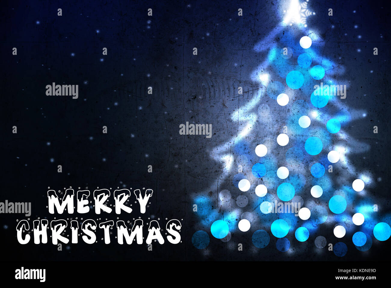 Merry Christmas wish on greeting card with Christmas tree silhouette from blue lights Stock Photo