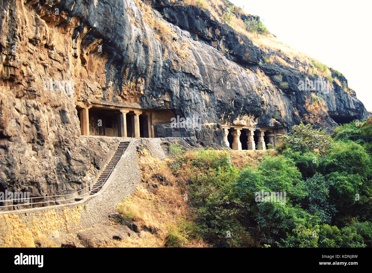 Stairs into the one of Ellora Caves. Entryways with carved columns. Aged photo. Complexes of the rock-cut monastery-temple caves in Maharashtra, India Stock Photo