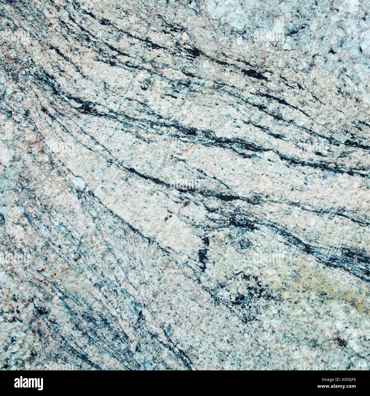 Wall of granite with stone layers of different colors. Texture. Toned
