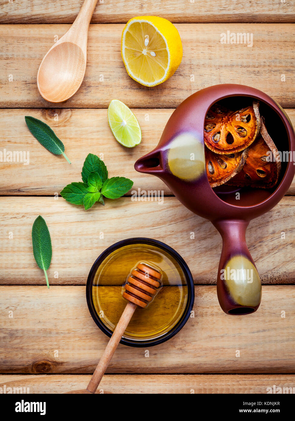 Herbal tea pot with fresh herbs sage ,peppermint ,dried indian bael, honey, lime and lemon on
