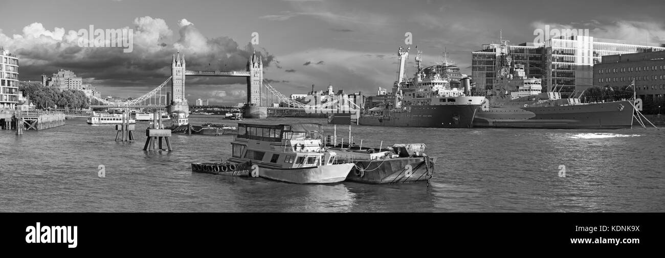 London - The panorama of the Tower bridge, riverside and cruiser Belfast in evening light with the dramatic clouds. Stock Photo
