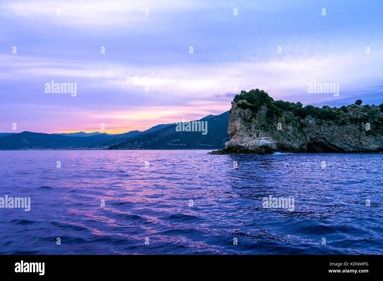 sunrise over the sea, behind the hill, with purple colors Stock Photo
