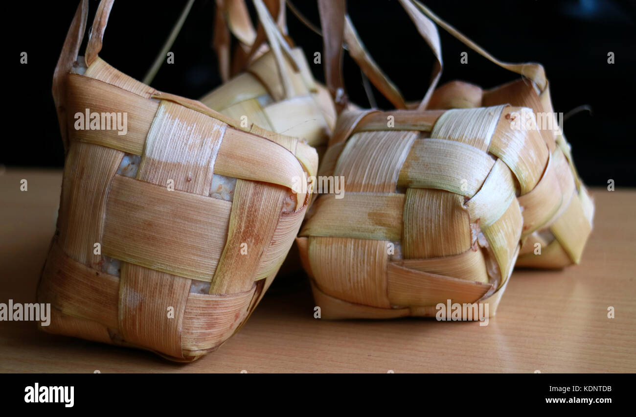Ketupat, Traditional Rice Cakes. A type of dumpling made from rice packed inside a diamond-shaped container of woven palm leaf pouch. Served on specia Stock Photo