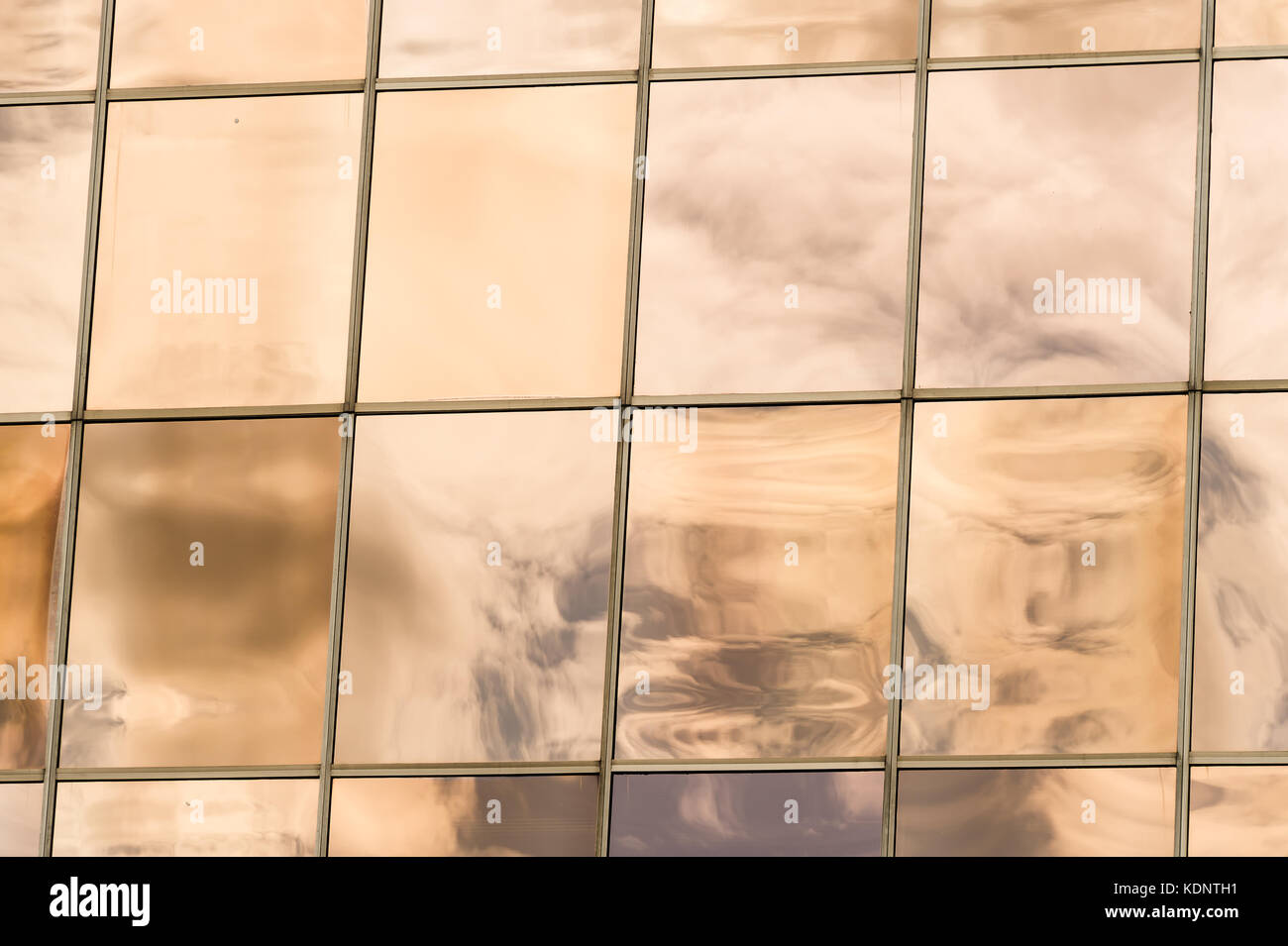 Clouds reflected in windows of modern office building Stock Photo