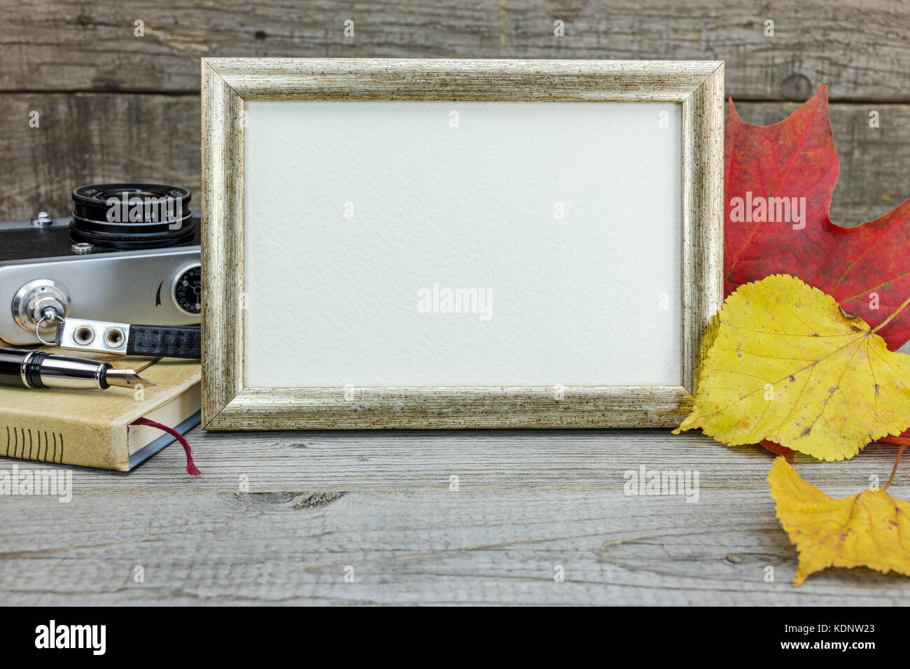 wooden table background with vintage camera, photo frame, notebook and ...