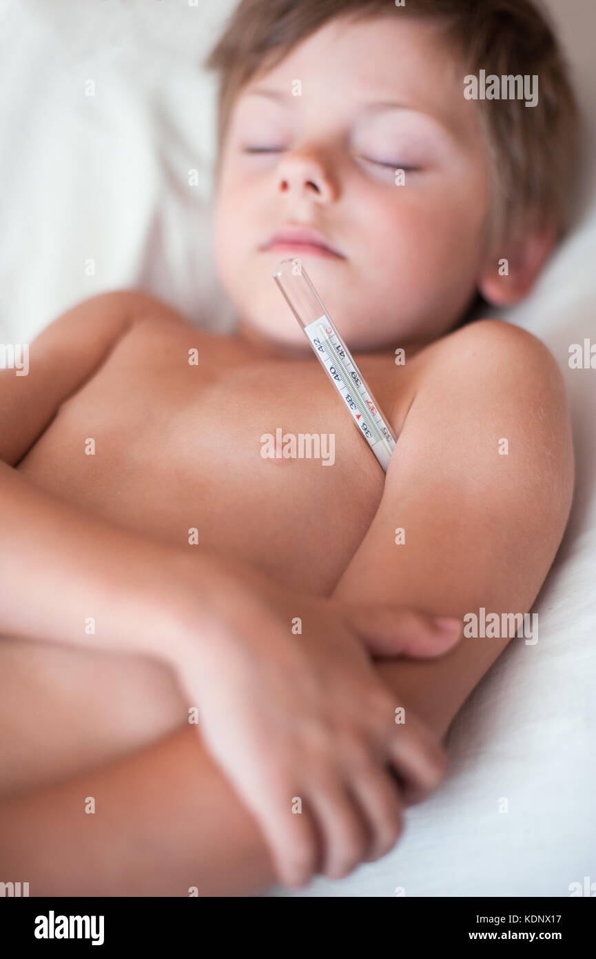 sleeping sick small boy lying with a thermometer in the armpit Stock Photo