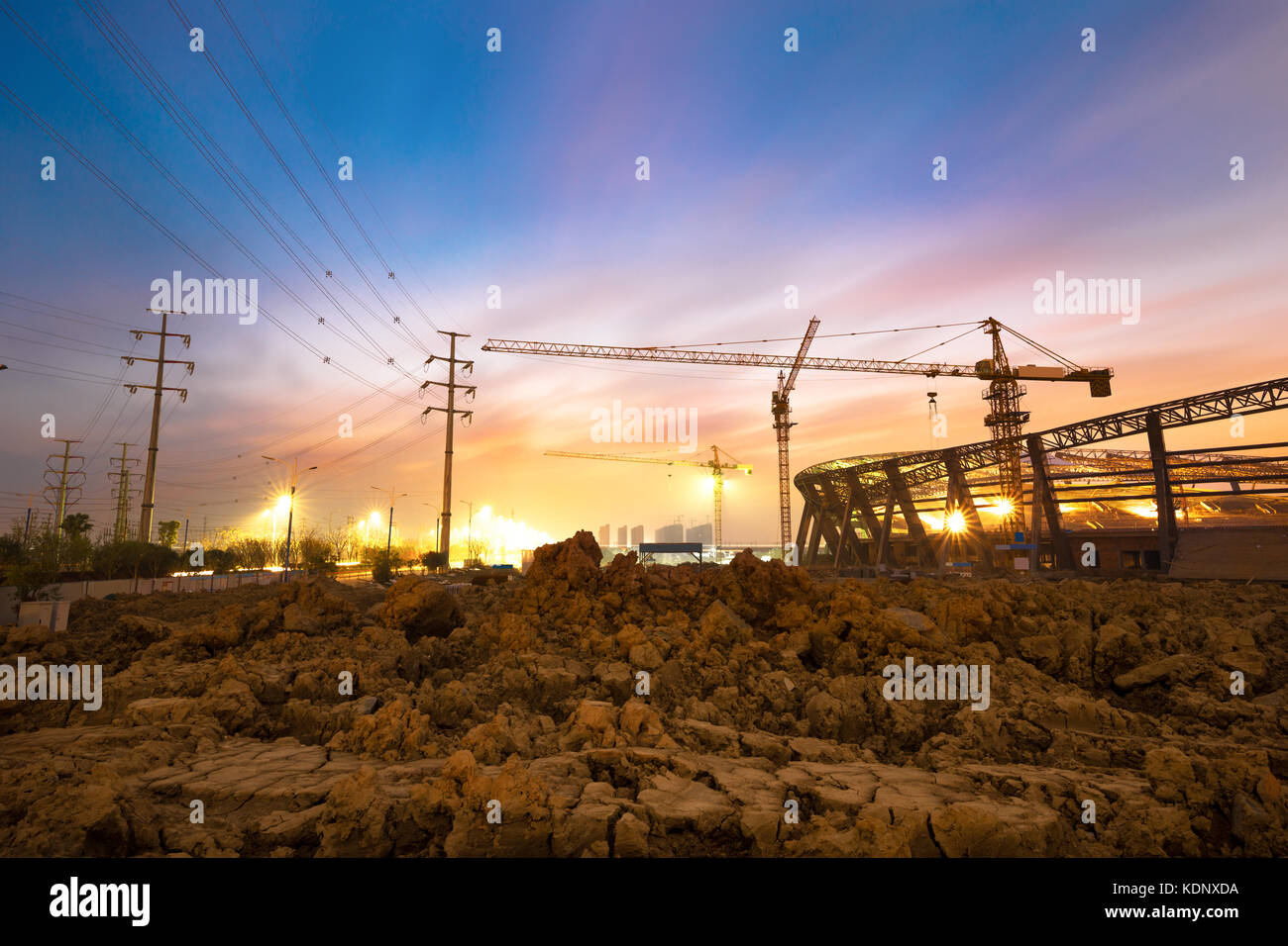 Lots of tower cranes build large residential buildings at night. Stock Photo