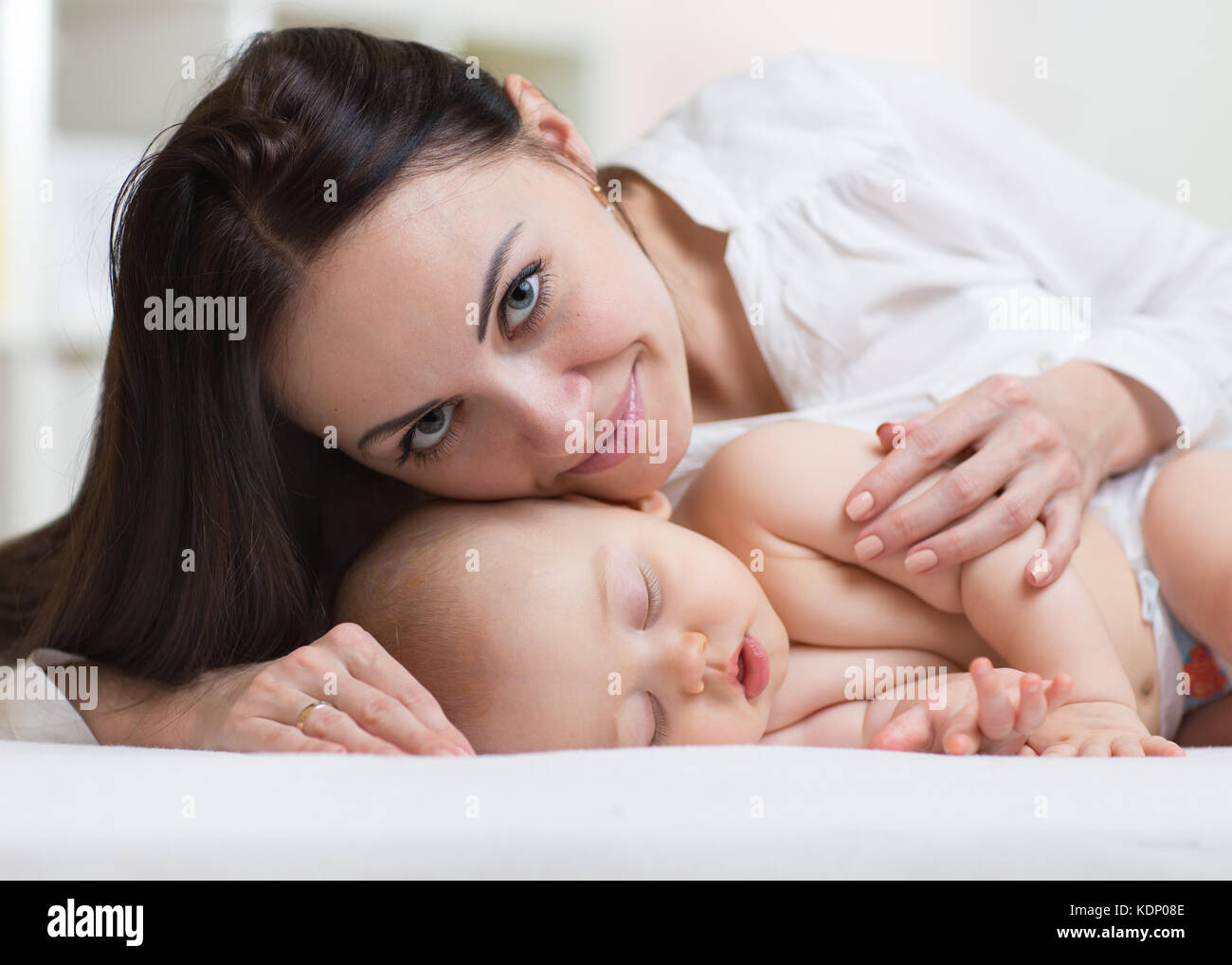 Close shot of a mother protecting her sleeping newborn baby Stock Photo