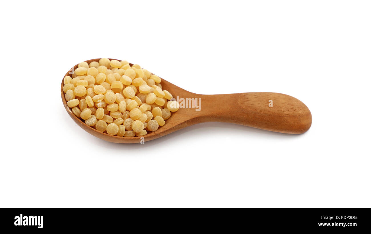 Traditional ptitim pasta (Israeli or pearl couscous) in wooden scoop isolated on white background, close up, high angle view Stock Photo