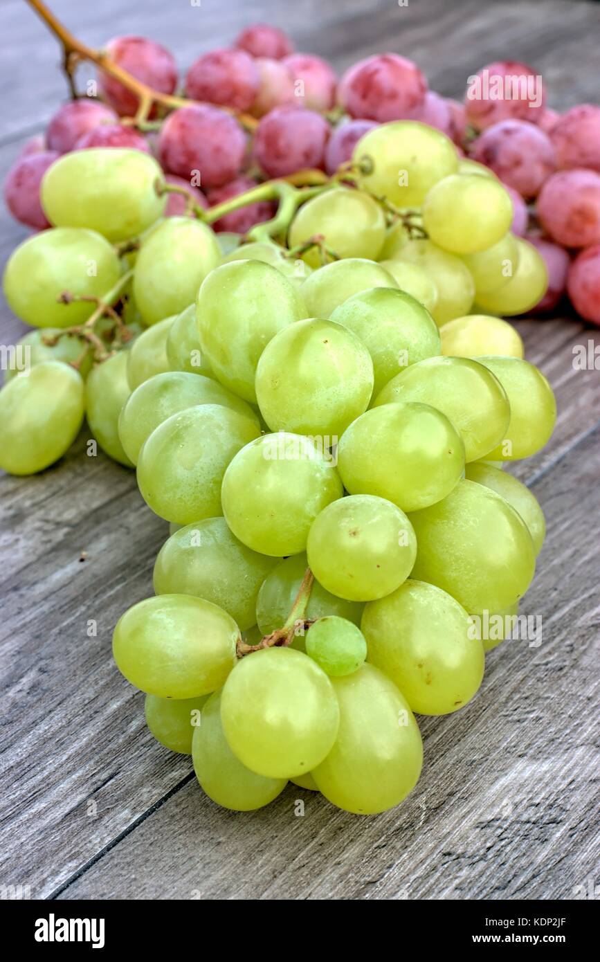 Ripe white and red grapes on a wooden background. Stock Photo