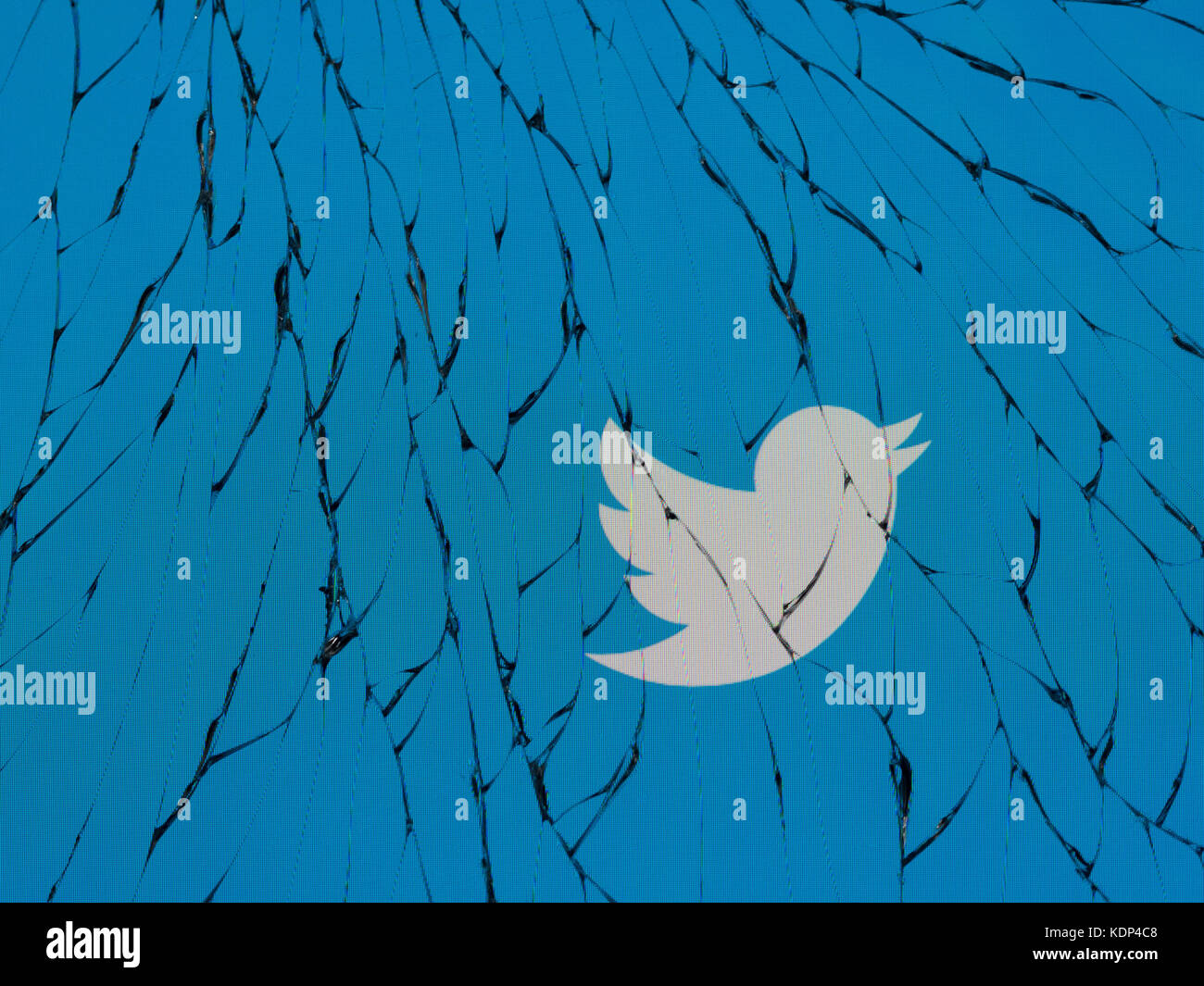 Twitter logo on a shattered iPhone screen Stock Photo