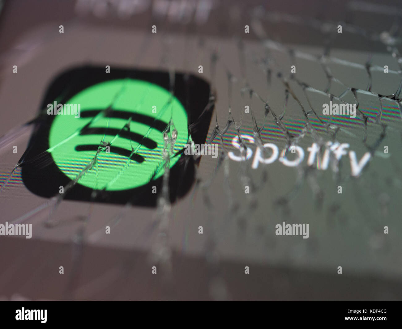 Spotify logo displayed on a broken smartphone screen Stock Photo