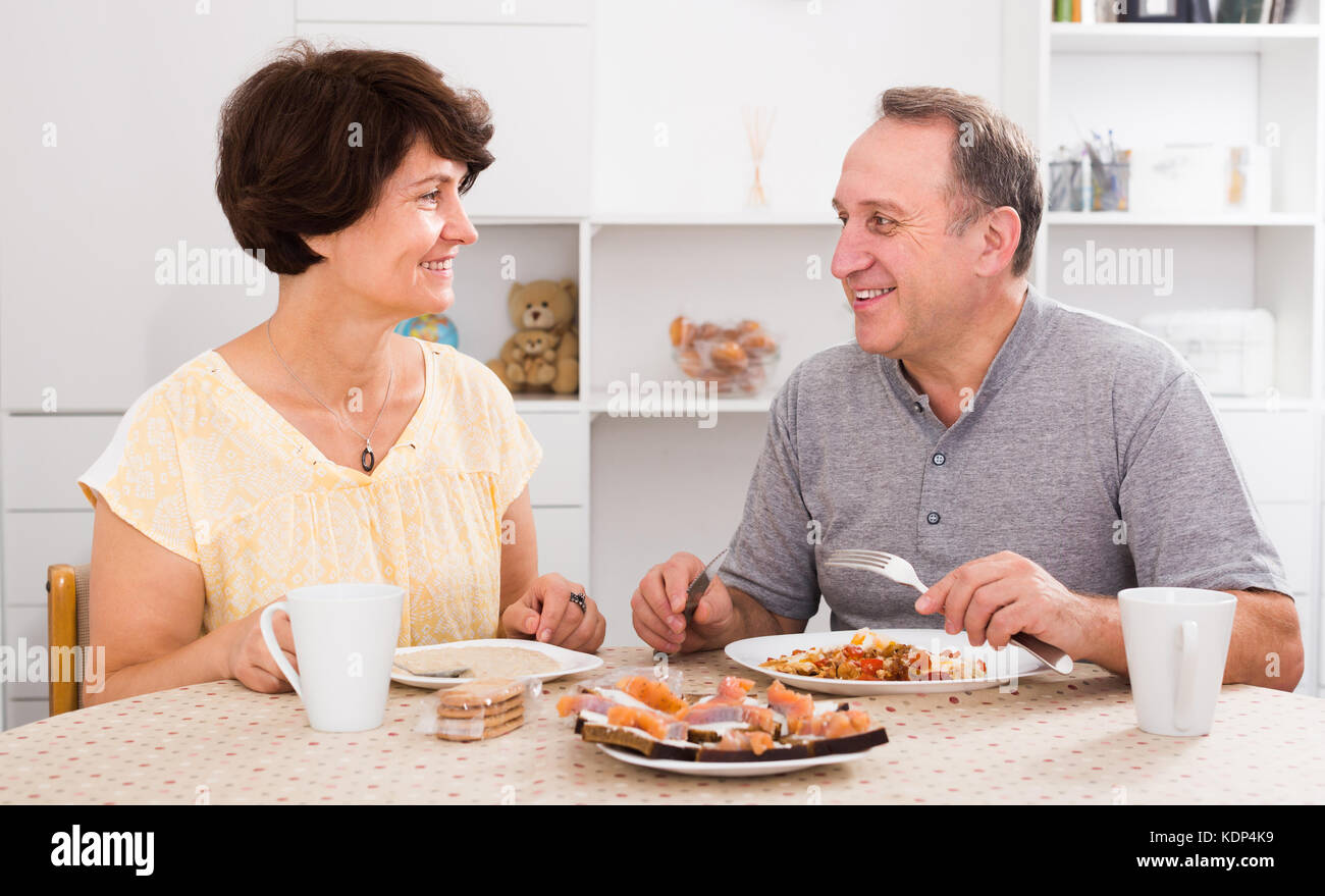 Laughing man and woman talking and having lunch together at home Stock ...