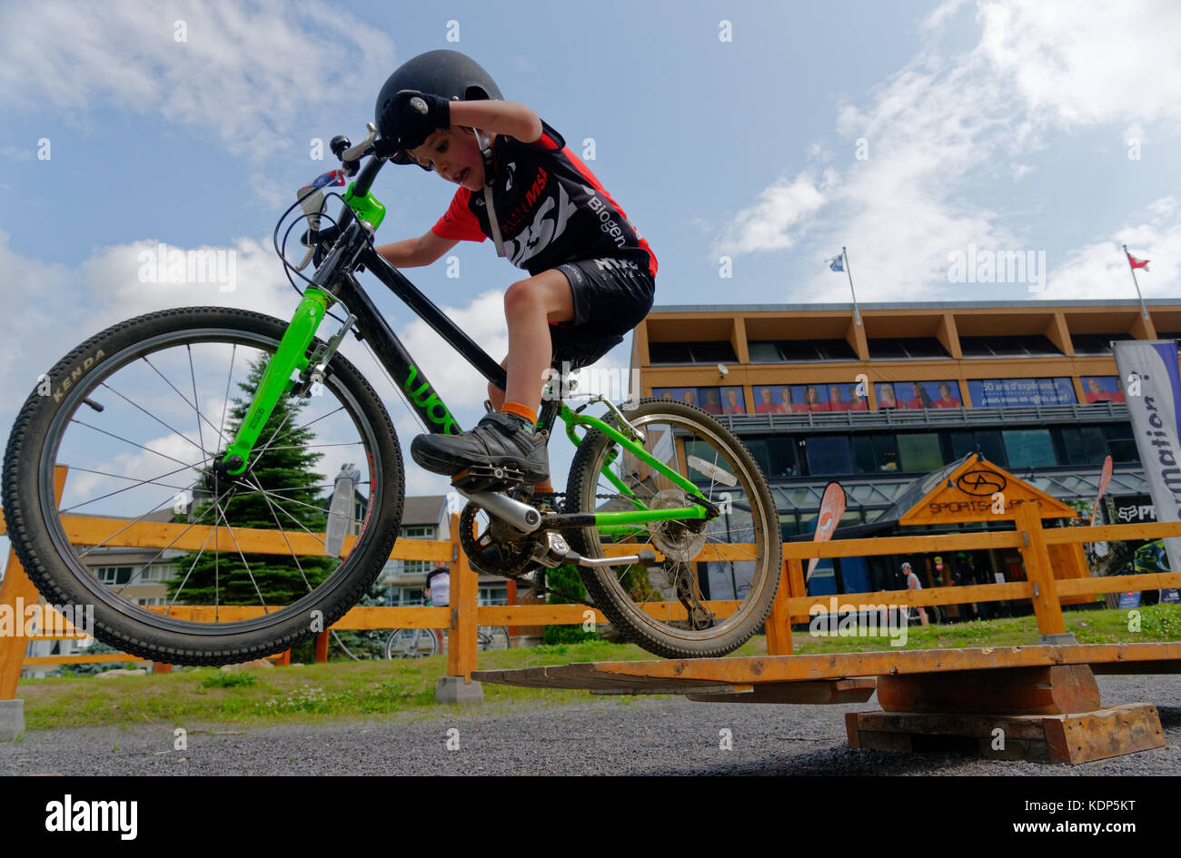 A young boy (5 yrs old) jumping in a mountain bike Stock Photo