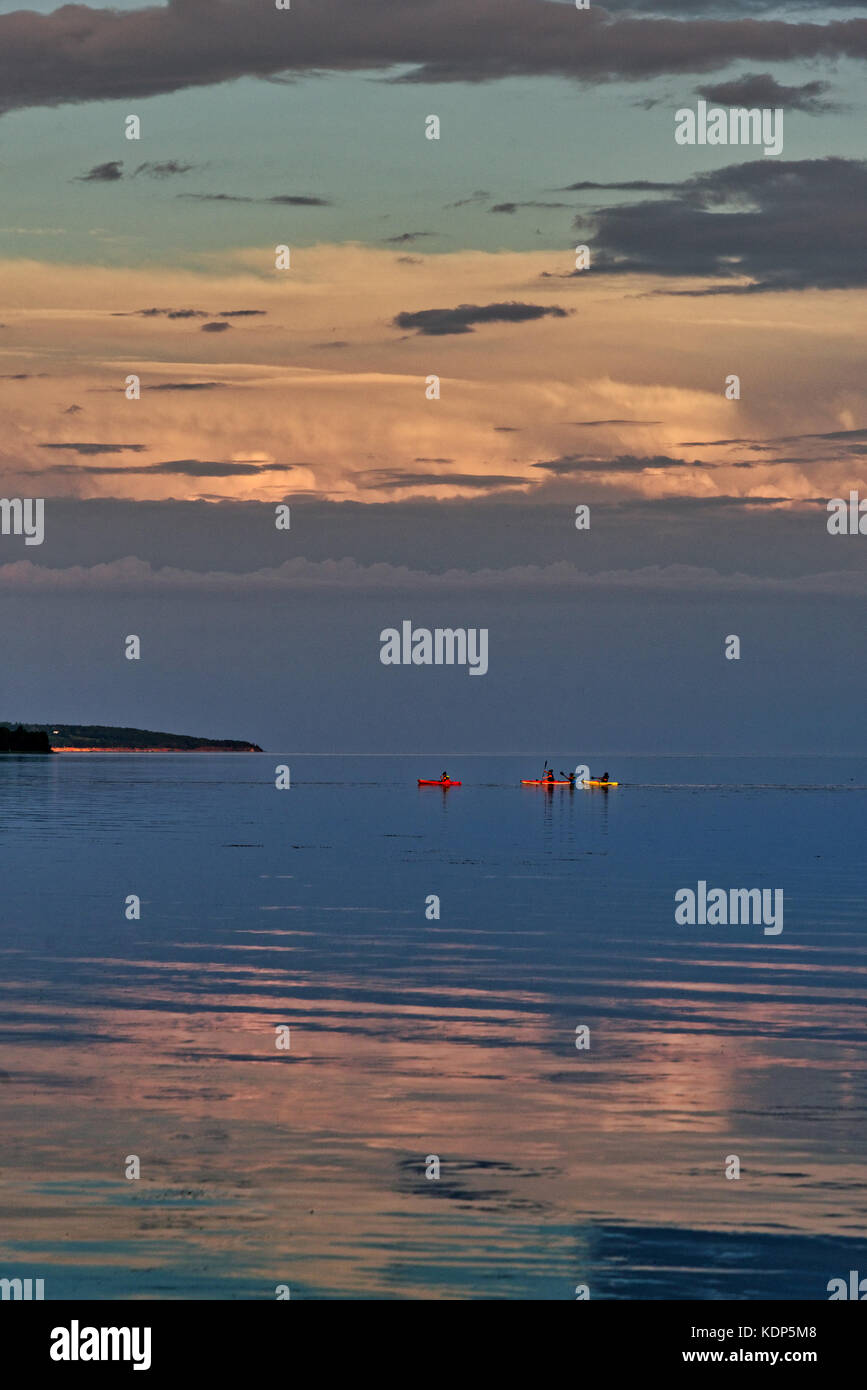 Kayakers crossing Baie des Chaleurs at sunset in Gaspesie, Quebec, Canada Stock Photo