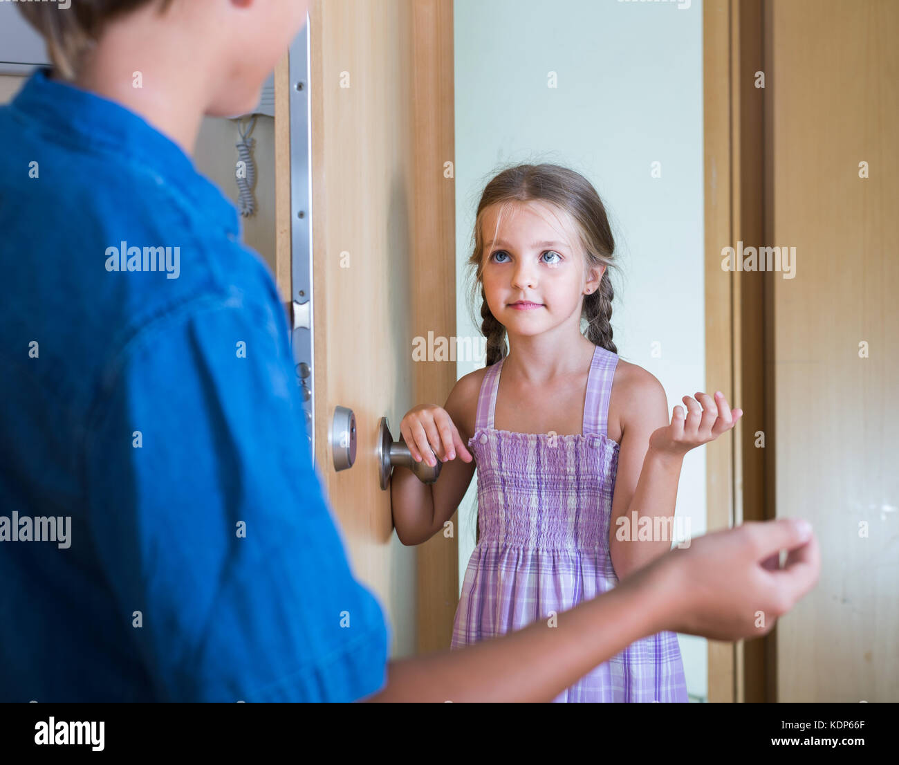 Hospitable child receiving expected friend at home interior. focus on
