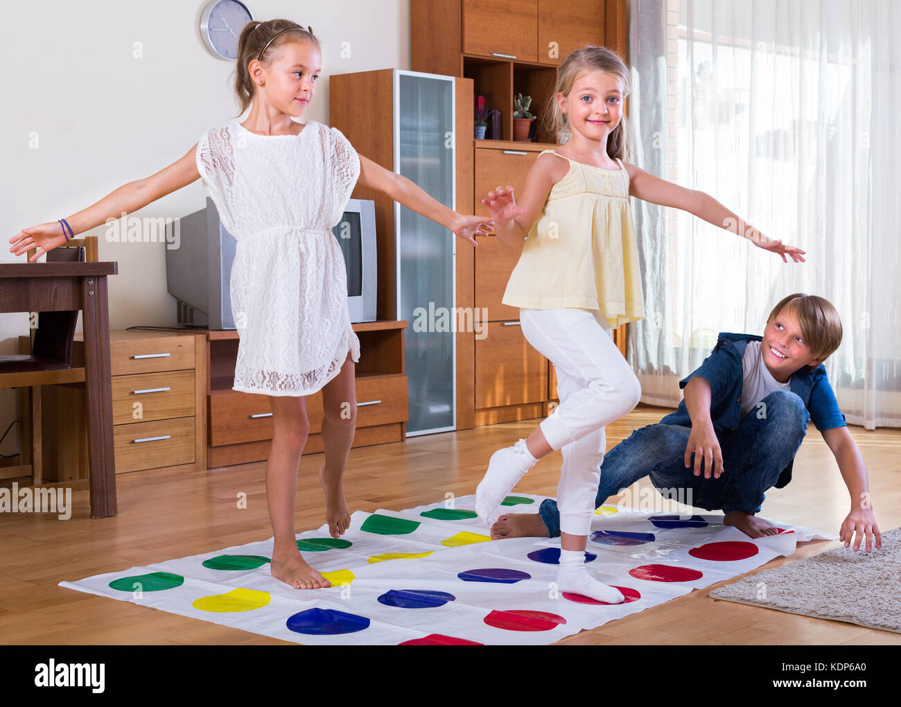 Group of happy children playing at twister in house Stock Photo