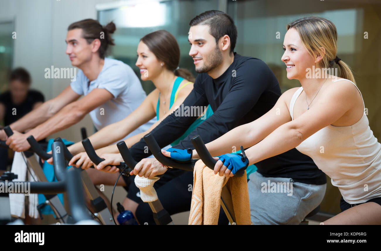 Group of young people training on exercise bikes in gym Stock Photo - Alamy