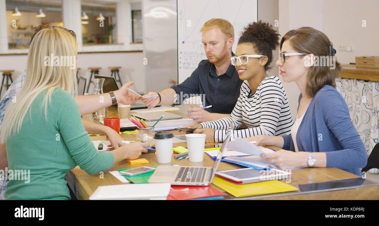 Cheerful team working at table Stock Photo - Alamy