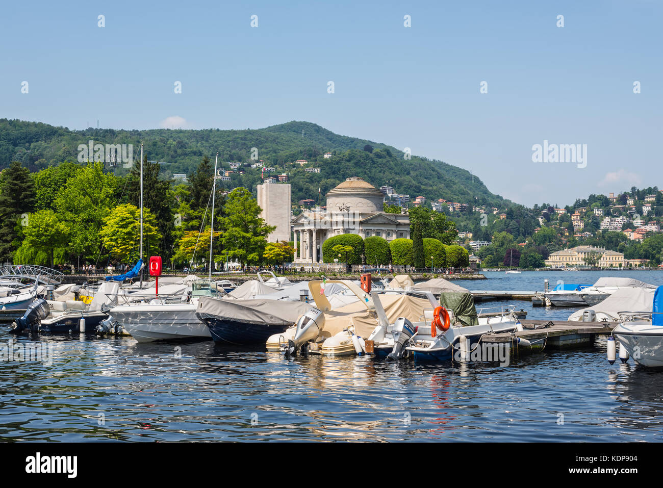 Como, Italy - May 27, 2016: Yachts and houses along Lake Como in Como town Lombardy region of Italy Europe. Volta Temple (Tempio Voltiano) in the cent Stock Photo