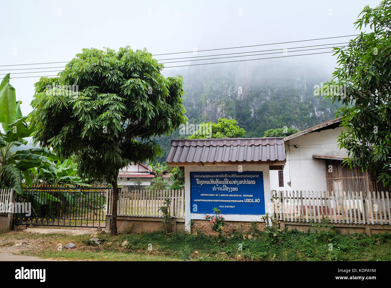 A sign in Nong Khiaw reading 'Department of Labour and Social Welfare, Lao National Unexploded Ordnance Programme (UXO Lao), Ngoi District' Stock Photo