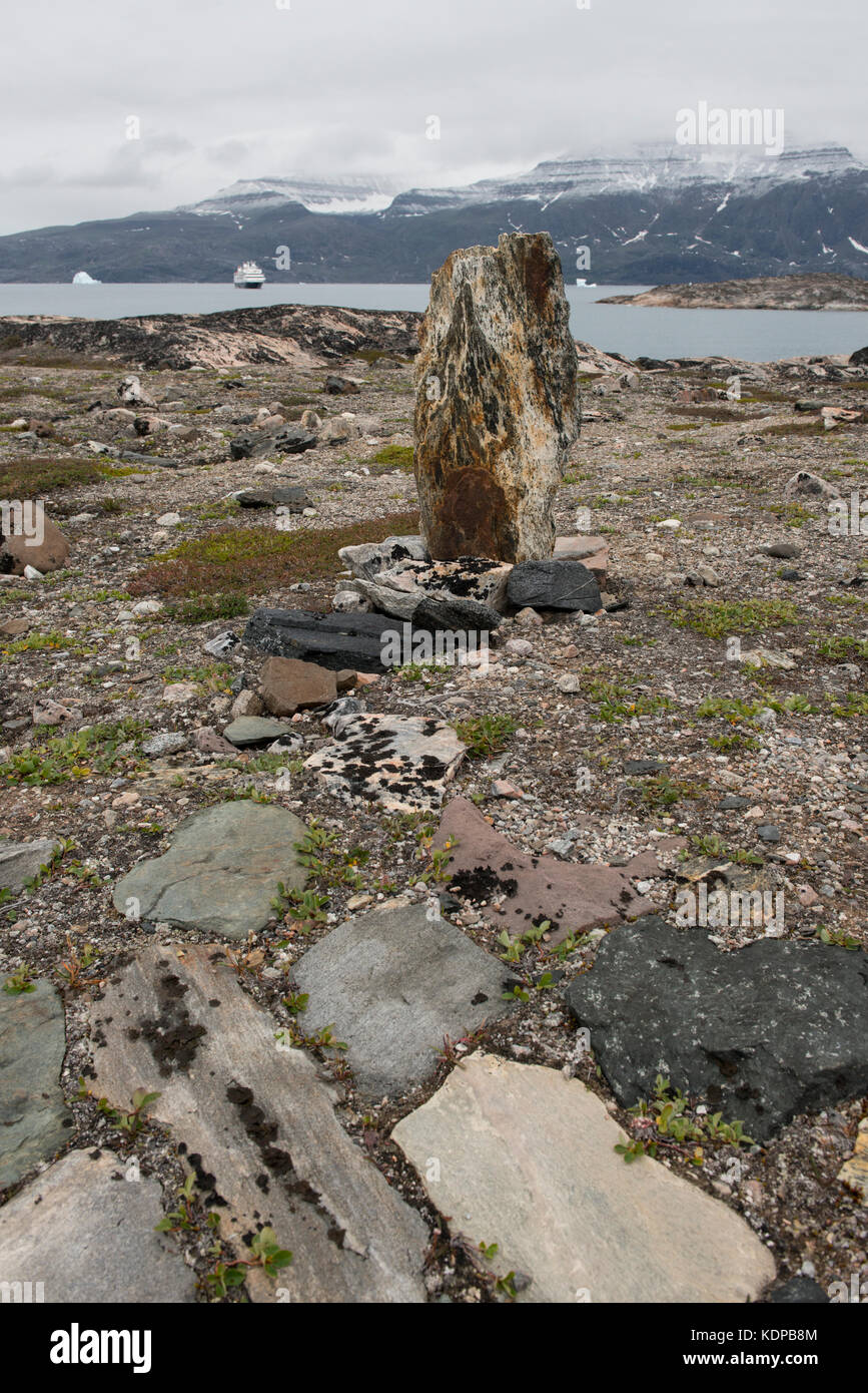 Greenland, Scoresbysund aka Scoresby Sund, Hekla Havn, Danmark O. Ruins of 200 year Inuit old tent rings. Expedition ship in the distance. Stock Photo