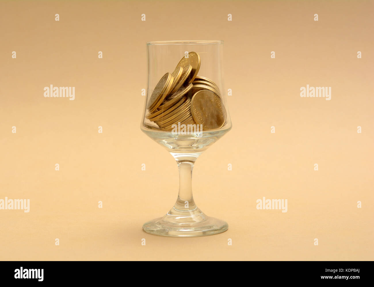 Glass Half filled with Golden Coins - Finance Concept. Stock Photo