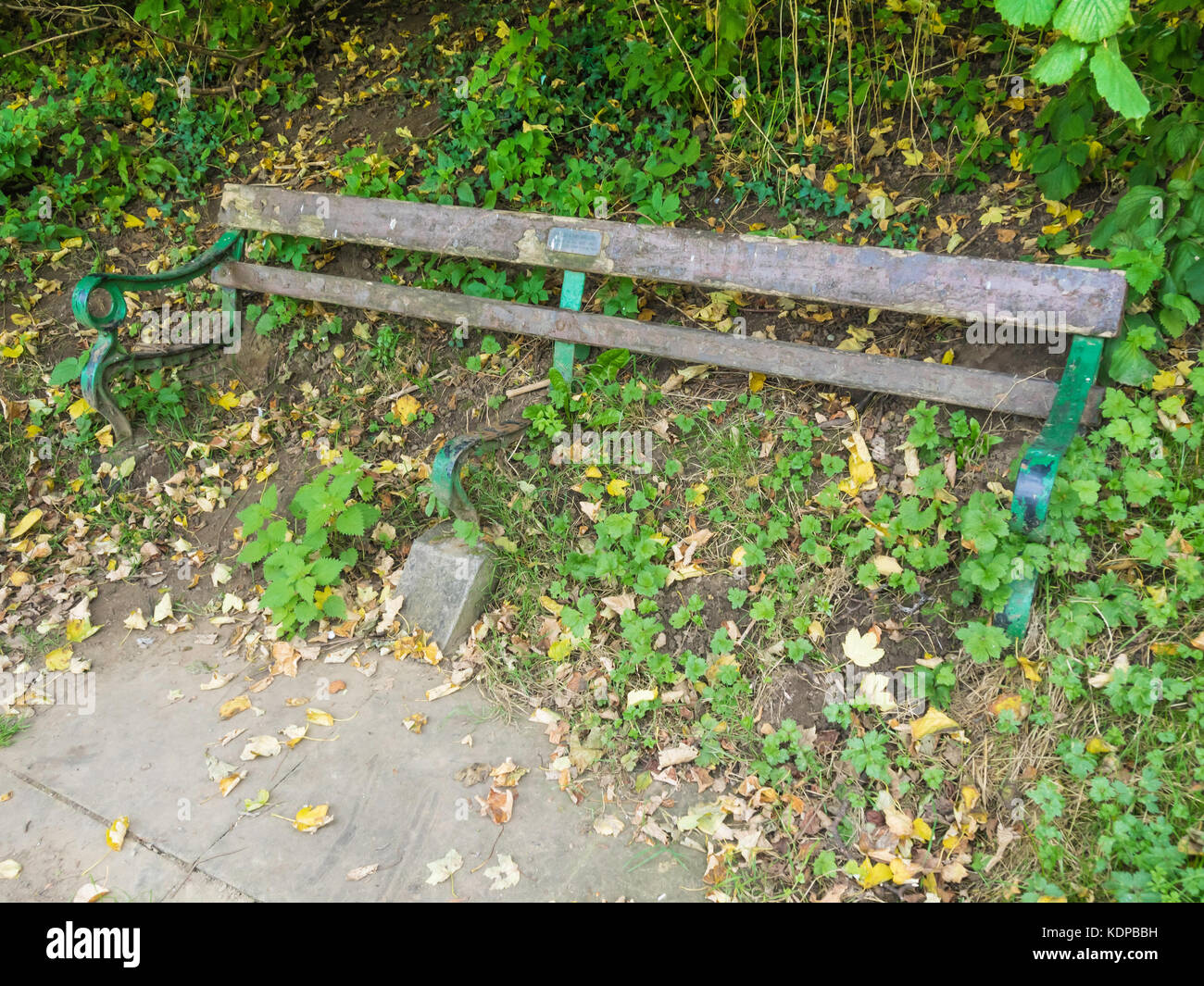 Public bench seat, with a dedication to a couple who died in 1987, with the seat timbers decayed and lost leaving the seat useless Stock Photo