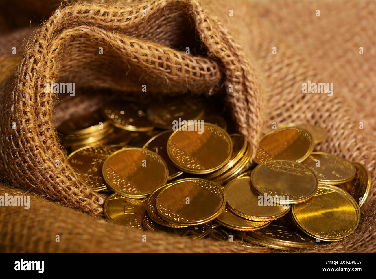 Jute Fabric full of Gold Coins - Luxury concept. Stock Photo