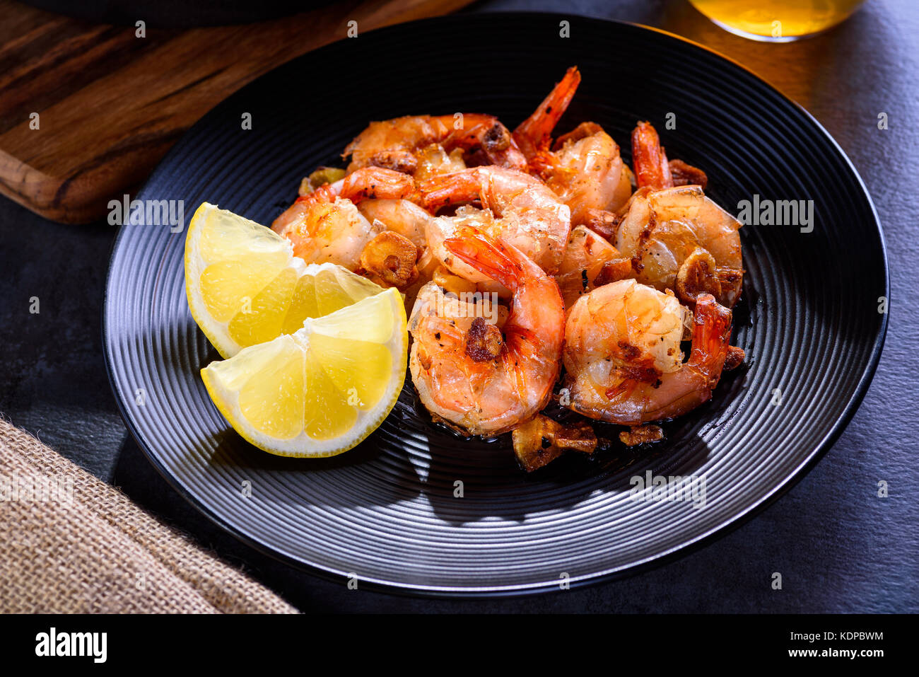 Skillet roasted jumbo shrimp on a black plate. Closeup. Shrimp roasted