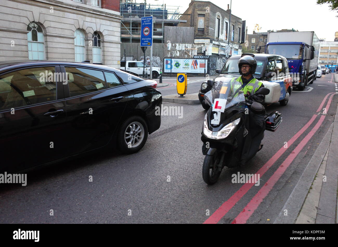 delivery rider on a moped with L plate sticker in London, England Stock
