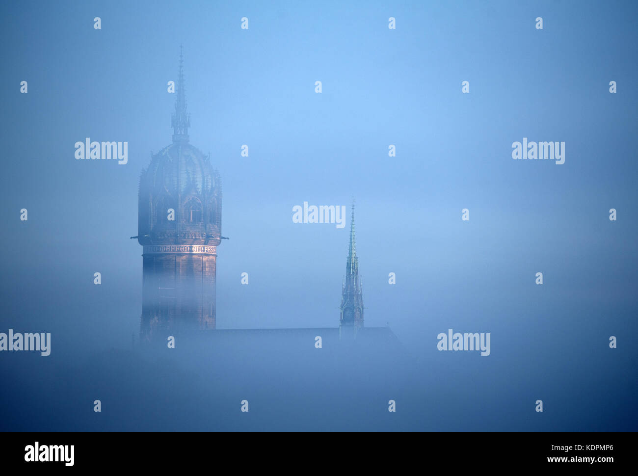 Wittenberg, Germany. 15th Oct, 2017. Morning fog passes the tower of the Schlosskirche in Wittenberg, Germany, 15 October 2017. This church has become famous for being the place where Martin Luther introduced his 95 Latin theses, which are seen to have instigated the Reformation. Credit: Ralf Hirschberger/dpa-Zentralbild/dpa/Alamy Live News Stock Photo