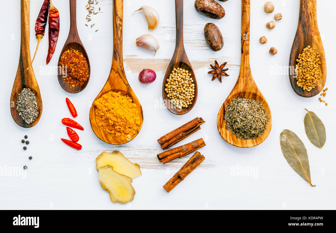 Various herbs and spices in wooden spoons. Flat lay of spices