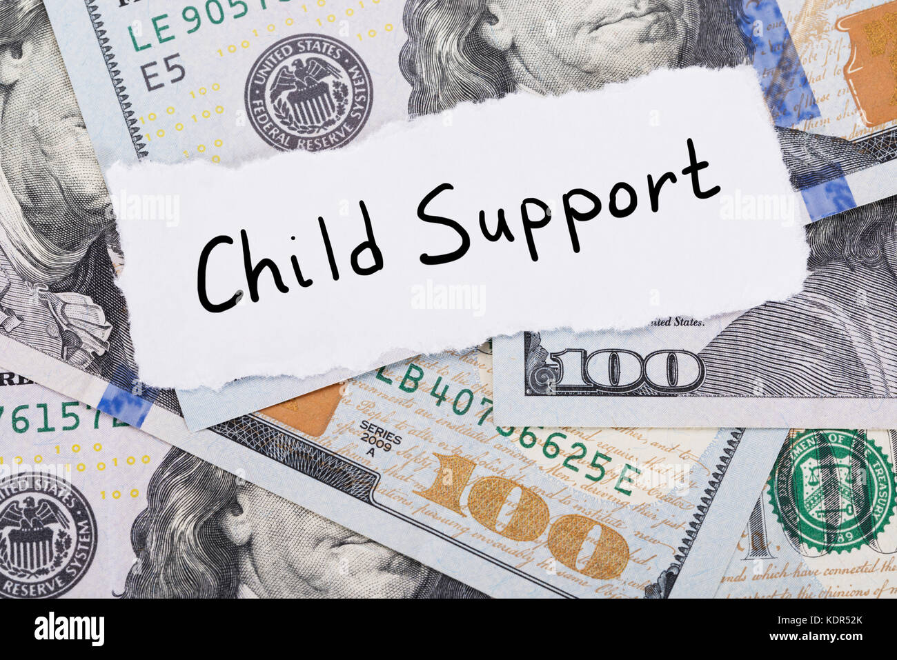High Angle View Of Dollar Notes With Child Support Note On Top Of That Stock Photo