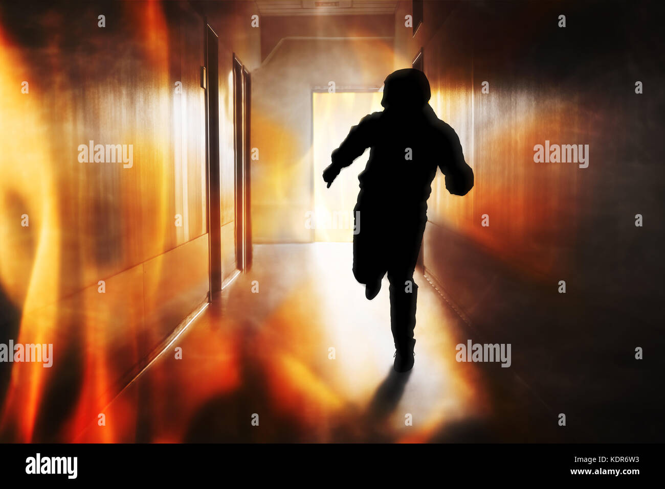 Silhouette Of Person Running Out Of Fire Escape On Corridor Of Building Stock Photo