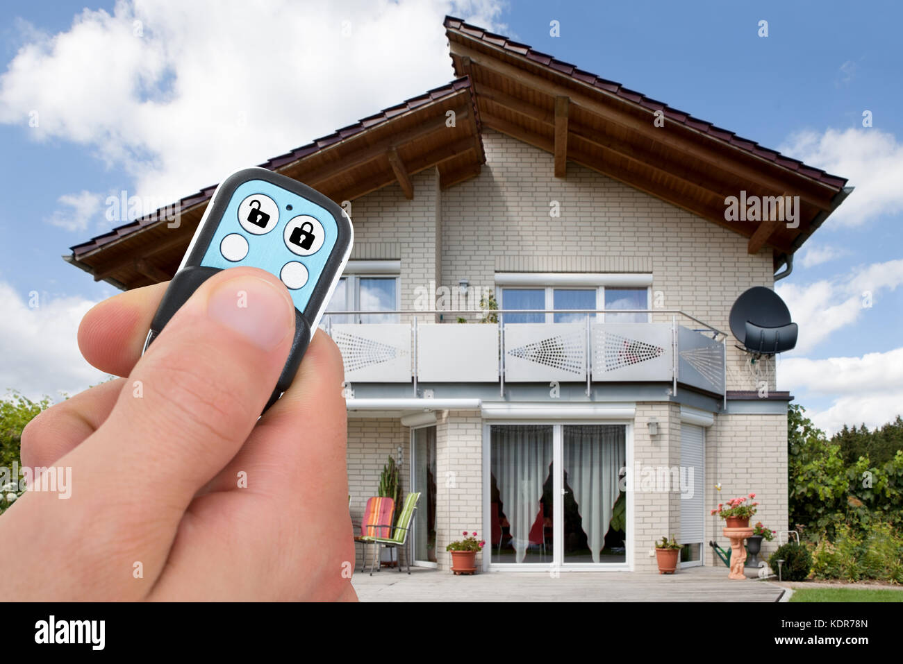Close-up Of Person Hand Using Remote Control Lock Outside The House Stock Photo
