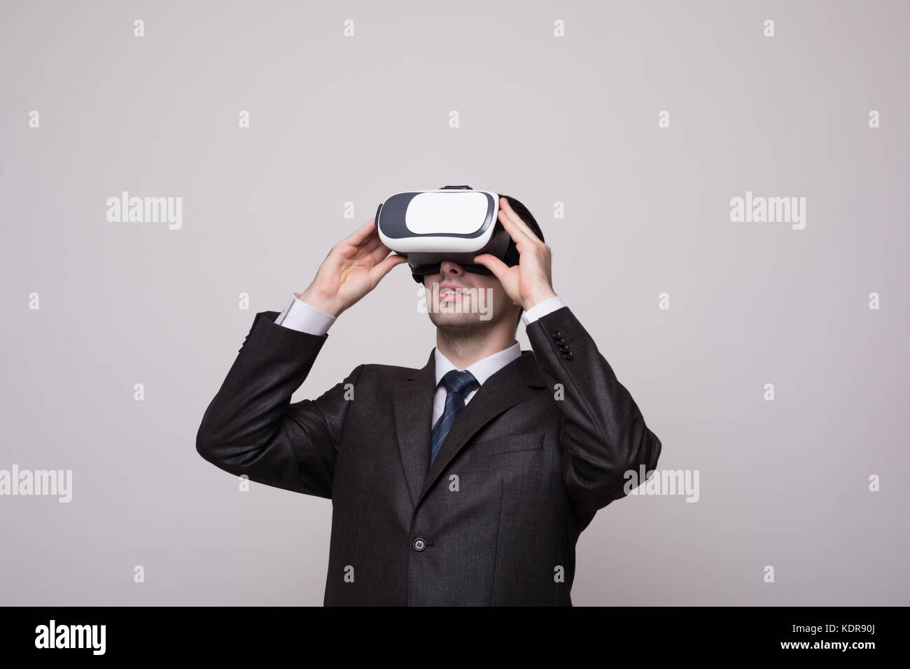 Young handsome businessman in black suit wearing virtual reality ...