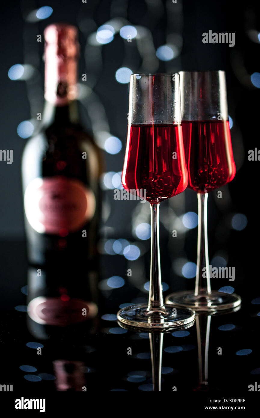 two glasses with pink champagne, bottle of champagne and Christmas ...