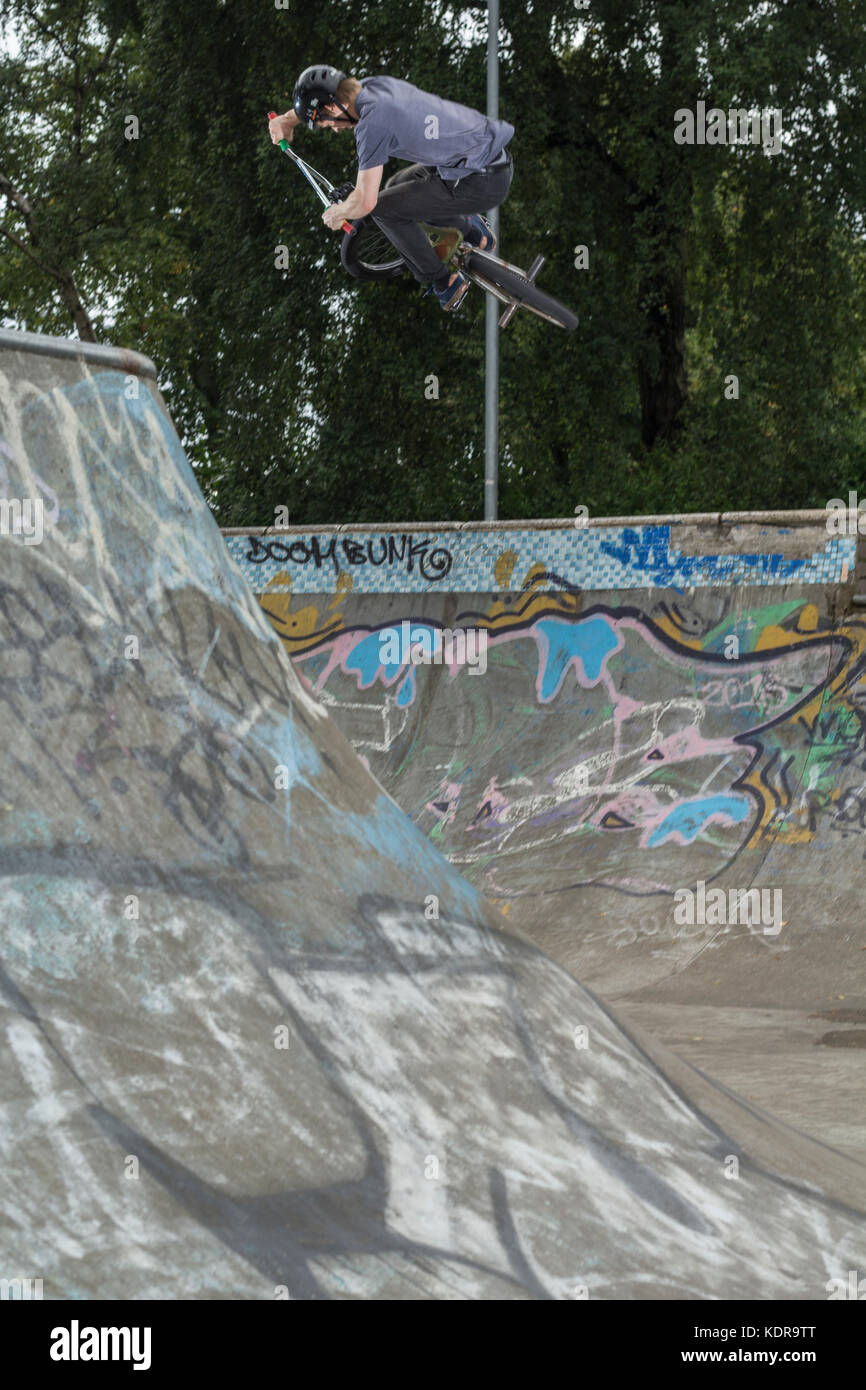 BMX rider getting air out of a ramp in a skatepark Stock Photo