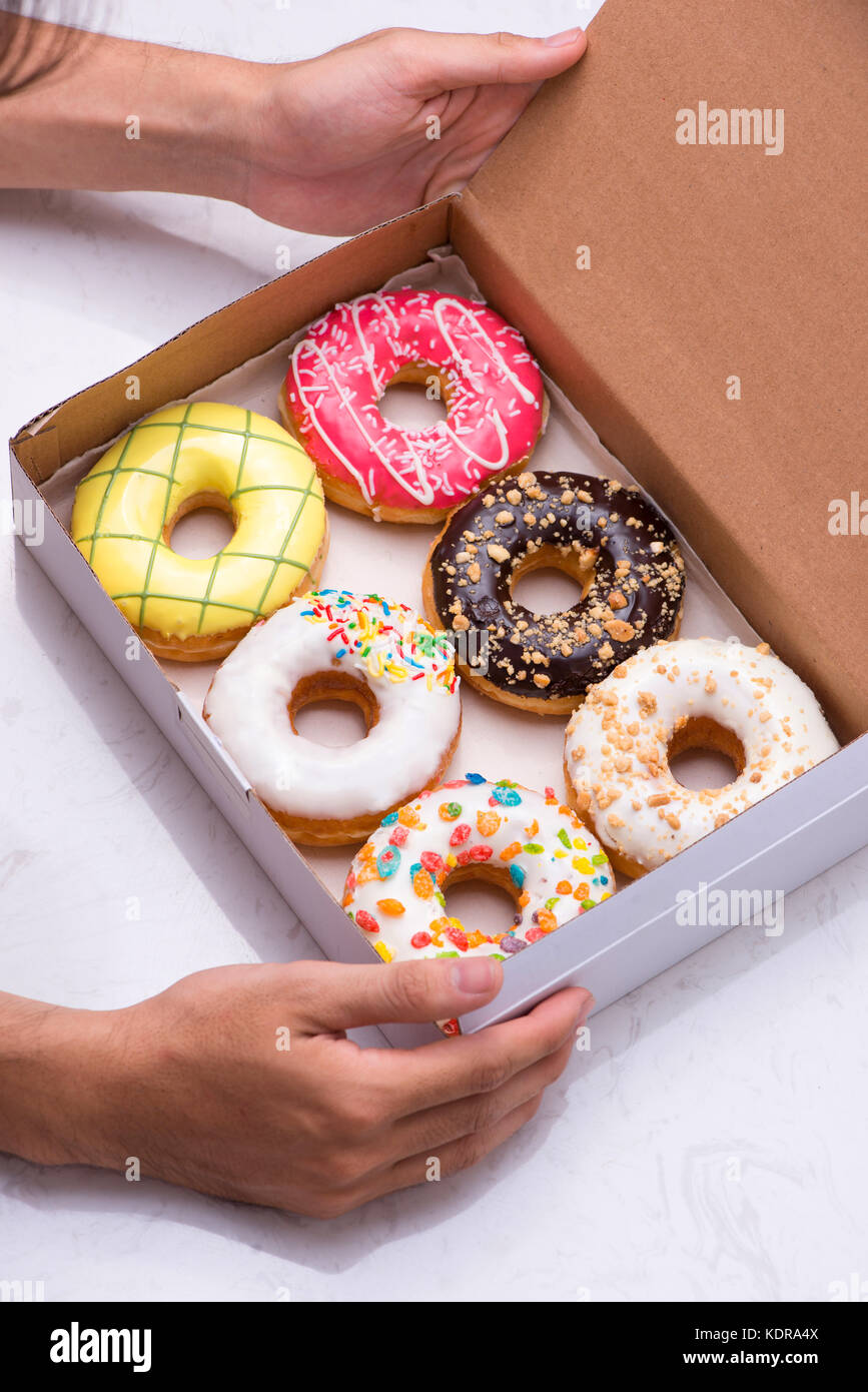 Colored donuts with glaze. Assorted doughnuts with different fillings in the box Stock Photo