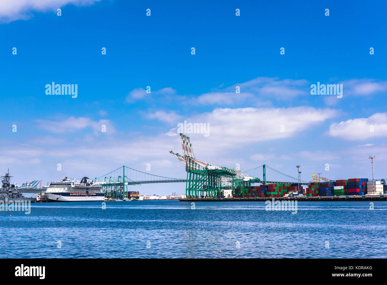 A cruise ship docked in ports of call in Long Beach California shows a heavy commerce transportation hub during a bright, sunny day. Stock Photo