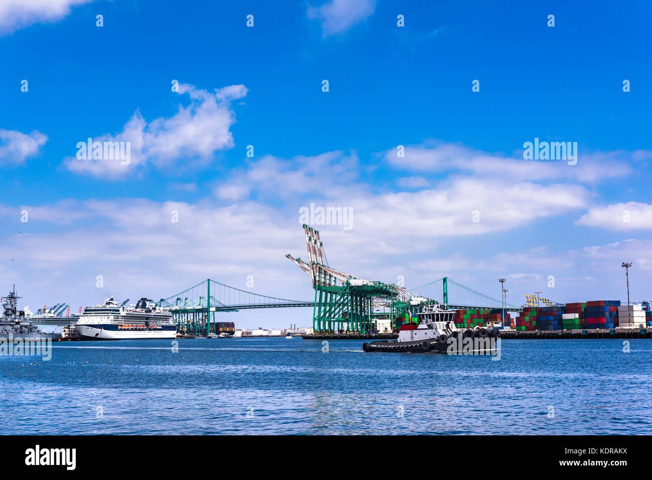 A tugboat motors across ports of call in Long Beach California in route to escort a freighter to the loading docks. Stock Photo