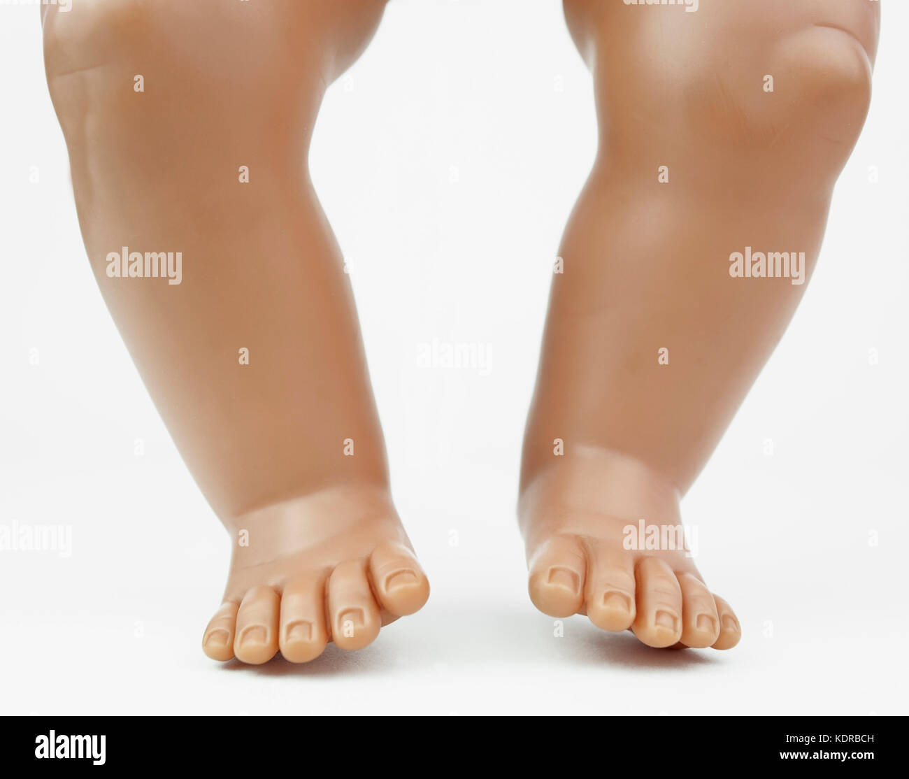 Standing baby doll legs and feet. White background. Stock Photo