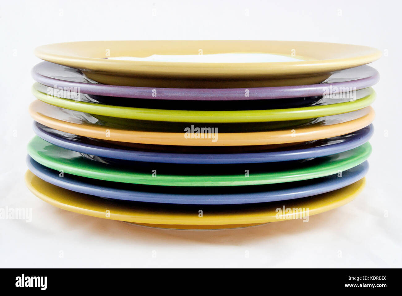 Side view of rims of handmade colorful ceramic plates. Isolated. Stock Photo