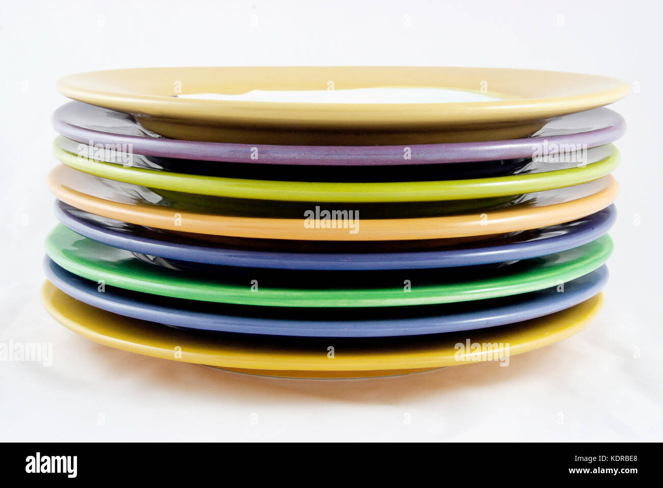Side view of rims of handmade colorful ceramic plates. Isolated Stock