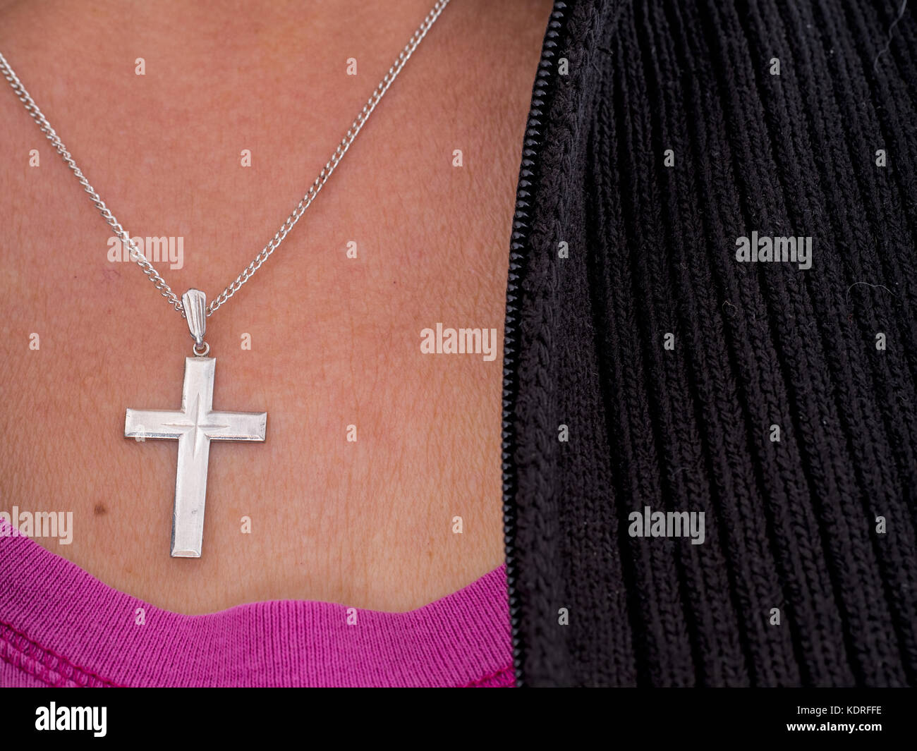 Woman with cross and chain, silver. Informal clothes, religious symbol. Stock Photo