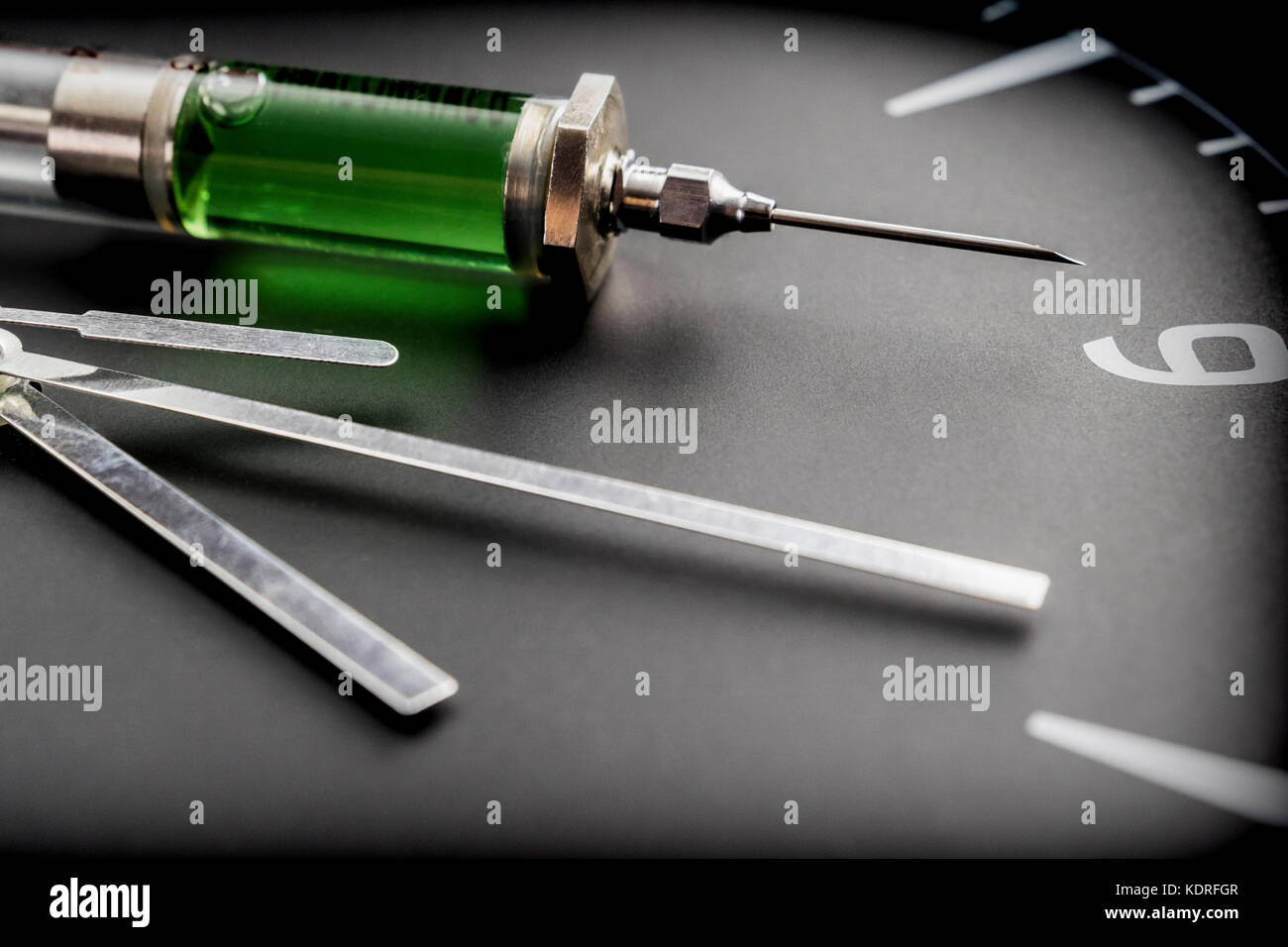 A syringe on a clock in laboratory, conceptual image Stock Photo