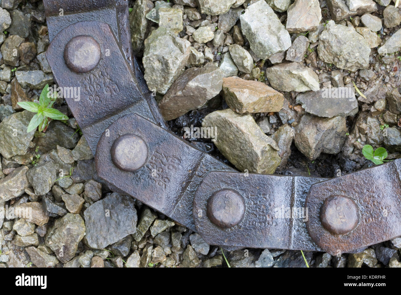 Chain on ground with gravel and weed Stock Photo