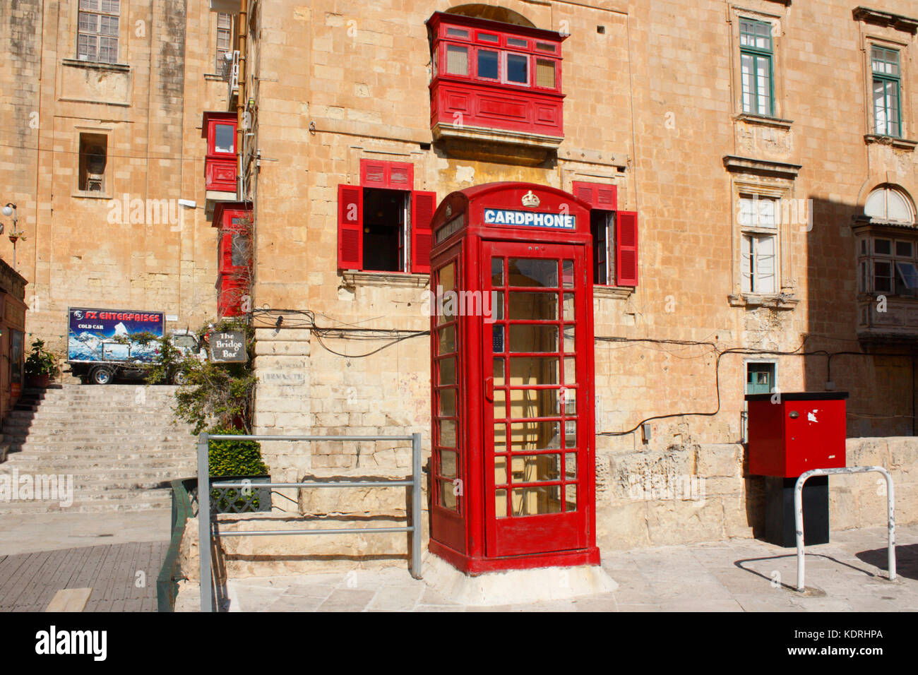 British style red telephone box in Battery Street, Valletta, Malta,  overlooked by red balcony Stock Photo - Alamy